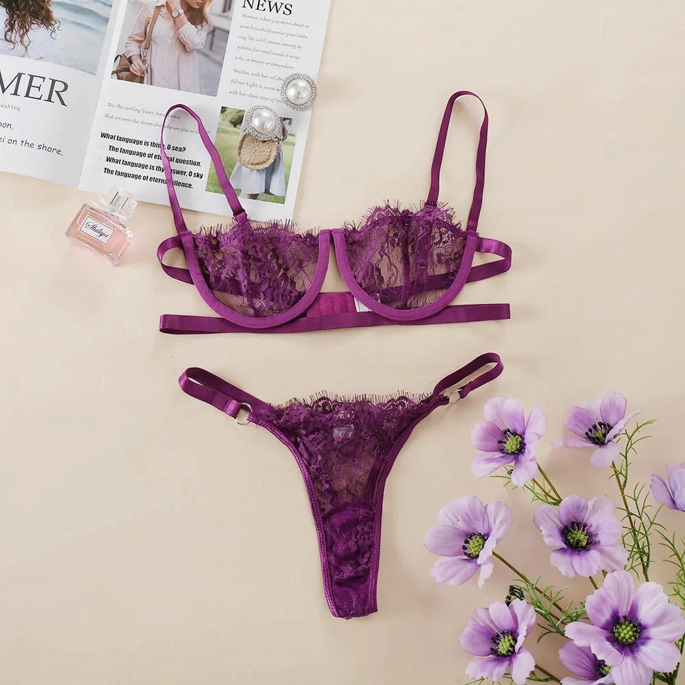 Purple lace lingerie set with flowers and magazine on a beige background