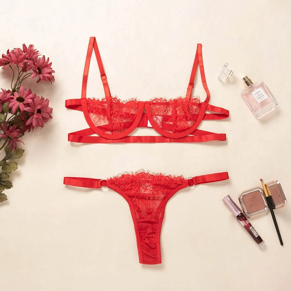 Red lace lingerie set with flowers and makeup on a beige background