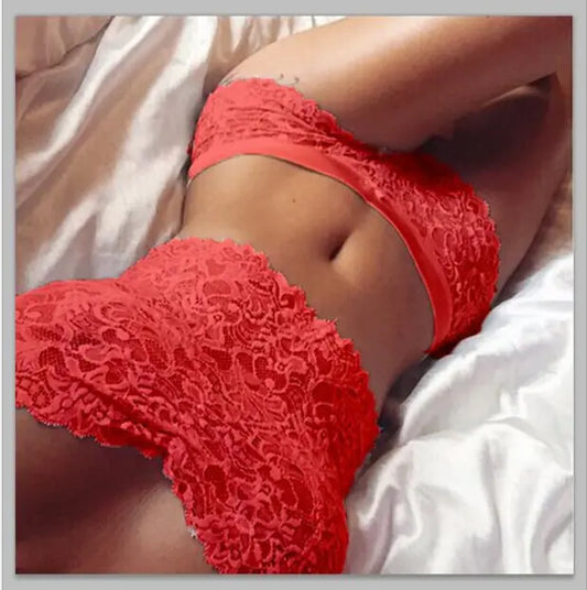 Person wearing red lace lingerie on a bed