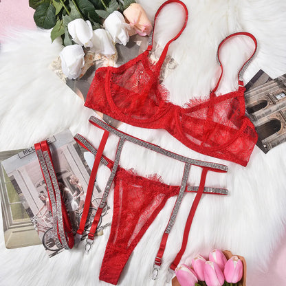 Red lingerie set with garters on a light surface with flowers and magazines.