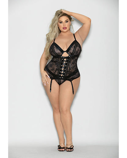 Woman wearing a black lace lingerie set on a plain background