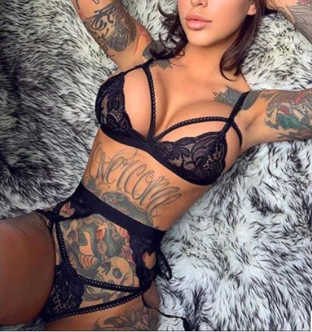 Person wearing black lace lingerie on a textured gray background