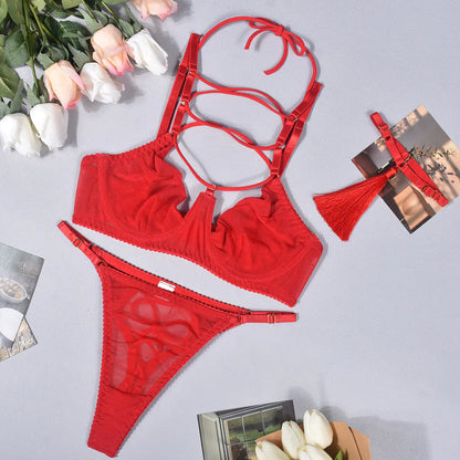 Red lingerie set with floral decorations on a light gray background