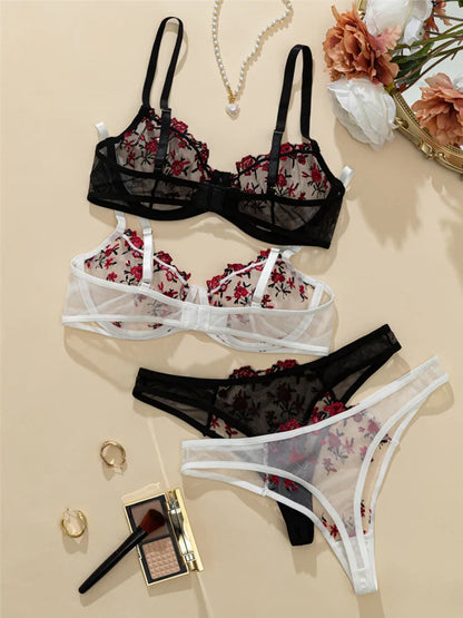 Set of black and floral lingerie on a beige surface with accessories.