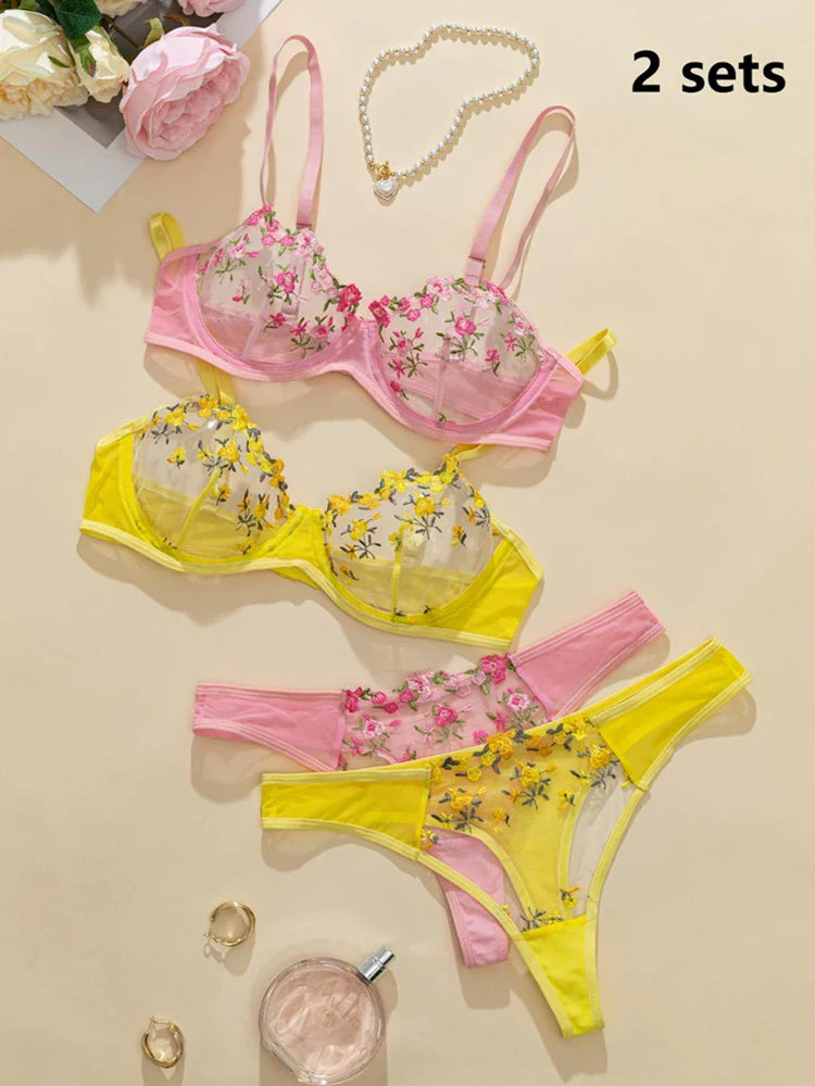 Floral lingerie set with pink and yellow colors on a beige background.