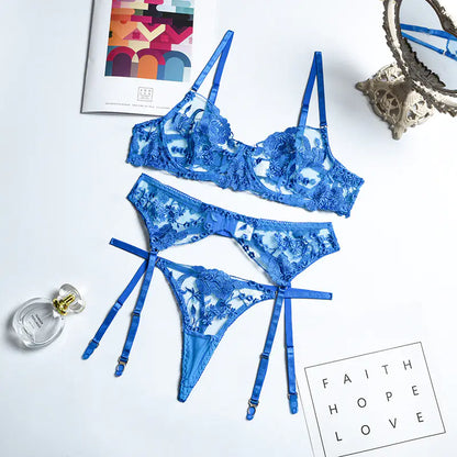 Blue lace lingerie set on a white surface with decorative elements.