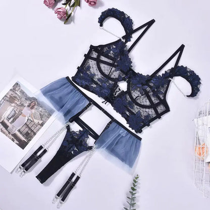 Navy blue lace lingerie set on a white background with flowers and a magazine.