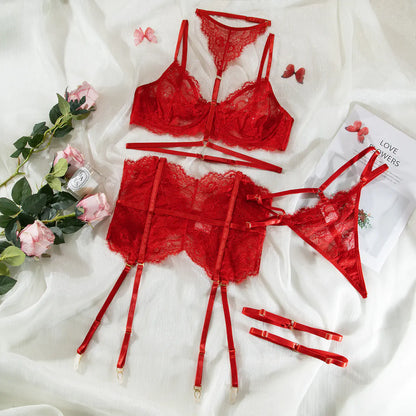 Red lace lingerie set on a white fabric background with flowers and a magazine.