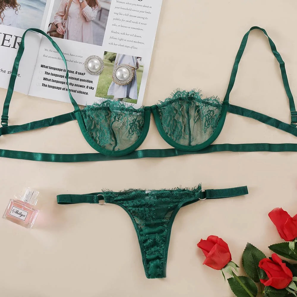 Green lace lingerie set with earrings and perfume on a magazine background