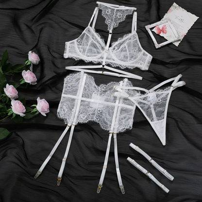 White lace lingerie set on a dark fabric background with roses.