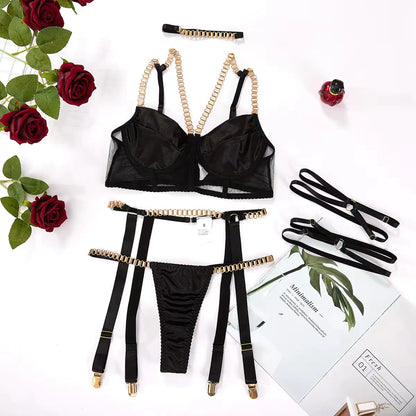 Black lingerie set with gold accents on a white background with roses and greenery.