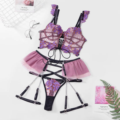 Purple and black lingerie set with floral designs on a white surface.
